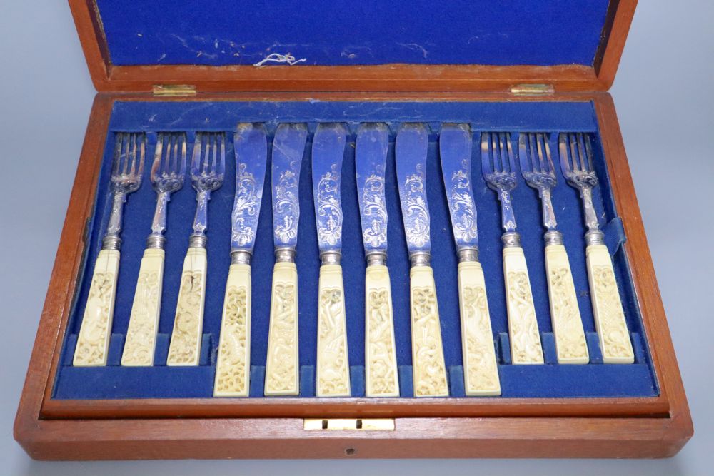 A Victorian set of twelve plated and engraved fish knives and forks, with carved ivory handles, mahogany cased